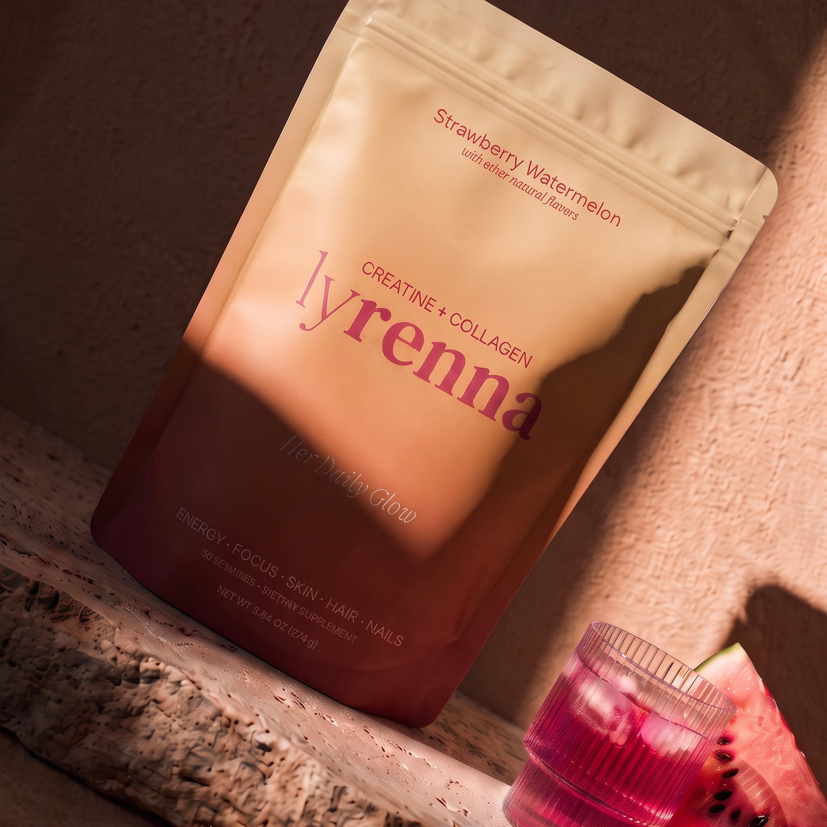 Lyrenna Creatine + Collagen pouch next to a strawberry watermelon drink